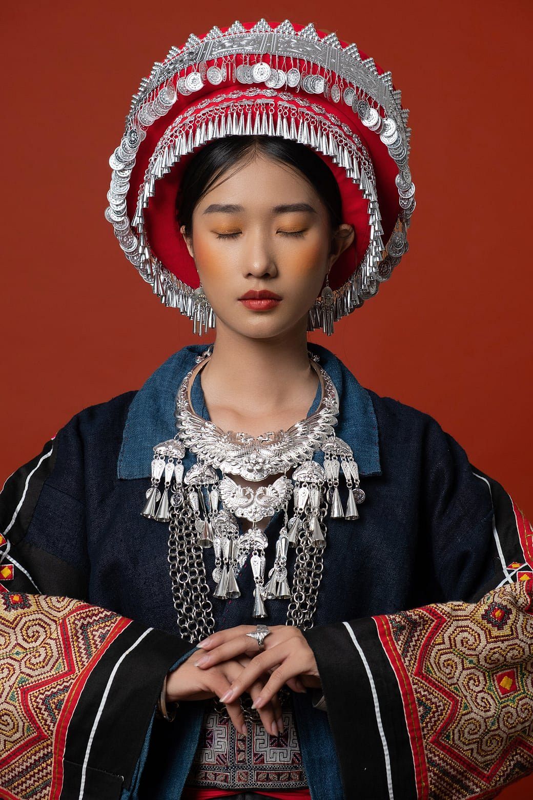 A H'mong ethnic woman at a highland market, wearing colorful attire