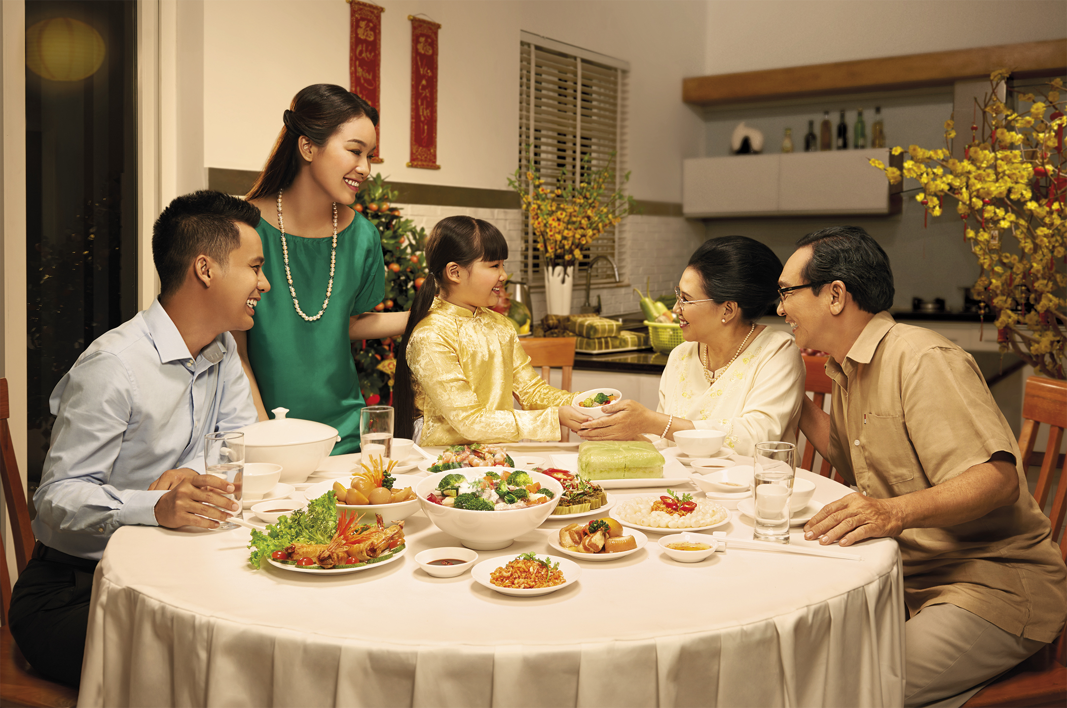 A modern Vietnamese family gathered around a meal — encompassing both the elderly and children — smartphones on the table