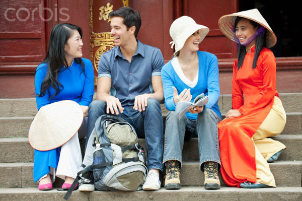 Foreign tourists conversing amicably with Vietnamese locals — a warm, welcoming atmosphere