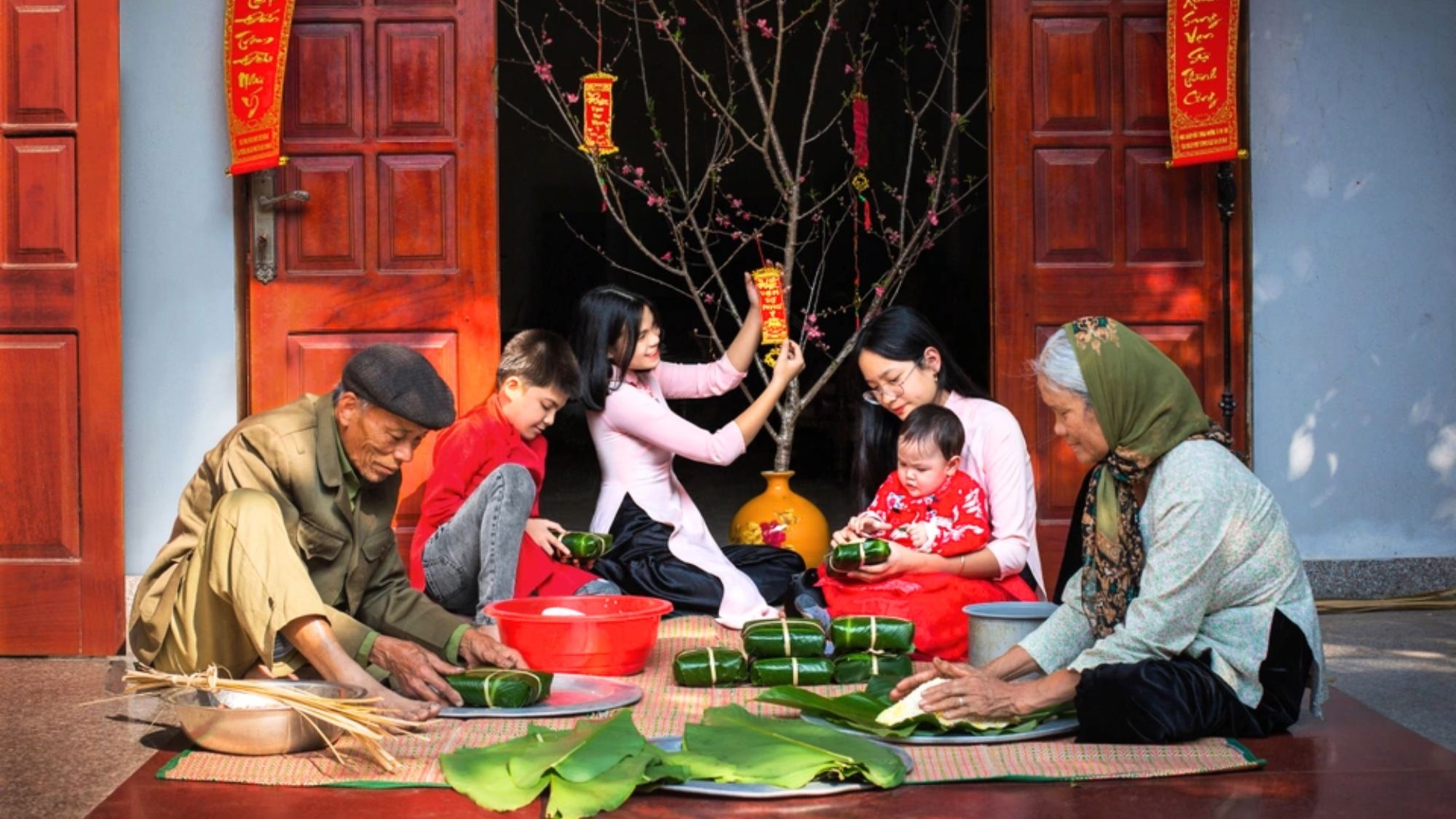 A Vietnamese person away from home during Tết — alone in a small room with a simple meal, making a video call