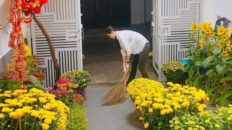 A Vietnamese family deep-cleaning their home at the end of the year — wiping down the altar, decorating