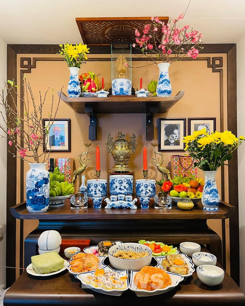 A fully adorned ancestral altar for Tết — flowers, fruit, bánh chưng, incense smoke