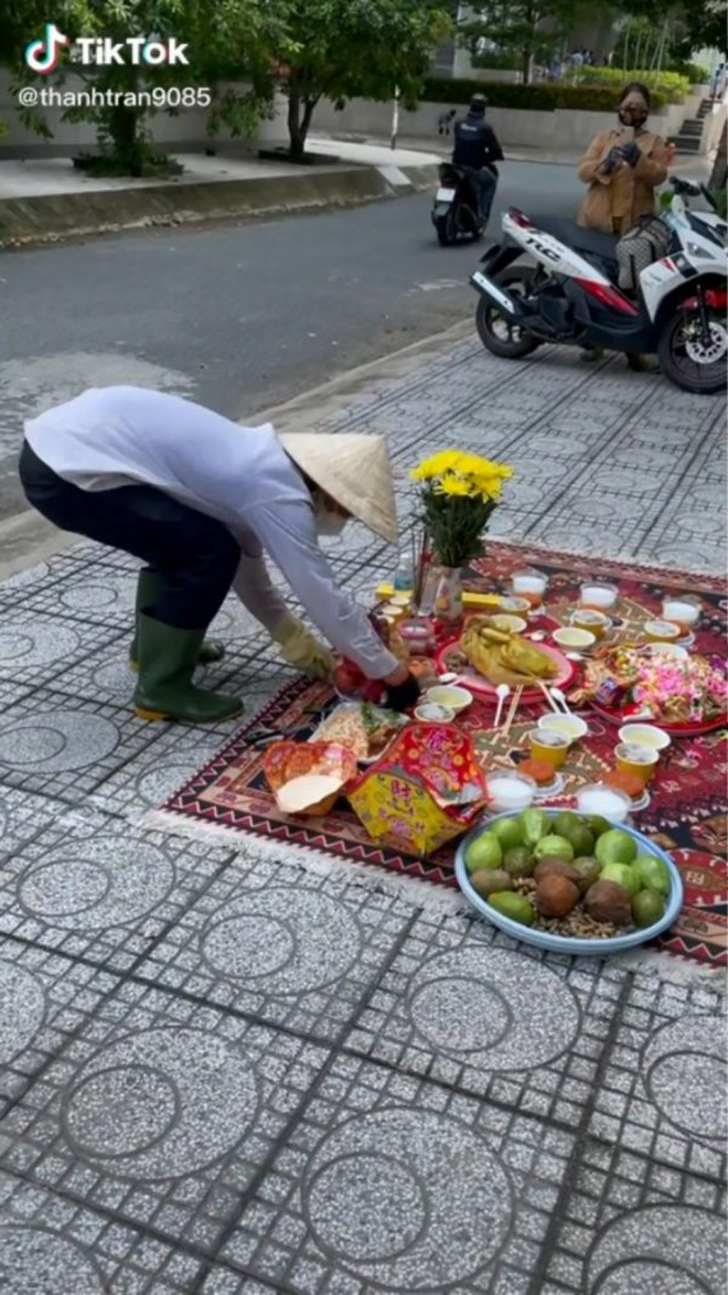 A feast for wandering spirits set out on the street — fruit, plain rice porridge, salt, and raw rice