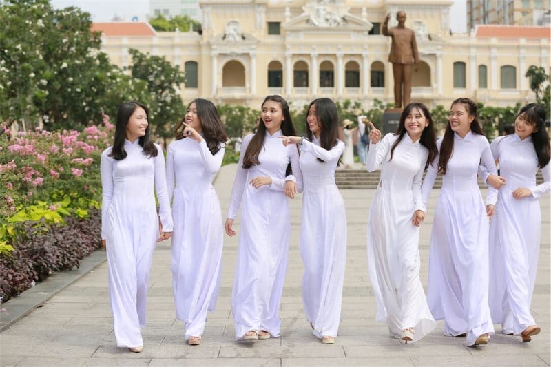 Modern Vietnamese female students wearing white Áo Dài to school