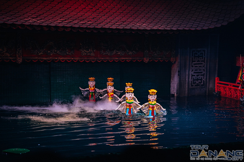 A water puppetry artisan standing submerged behind the screen — only visible from the waist up