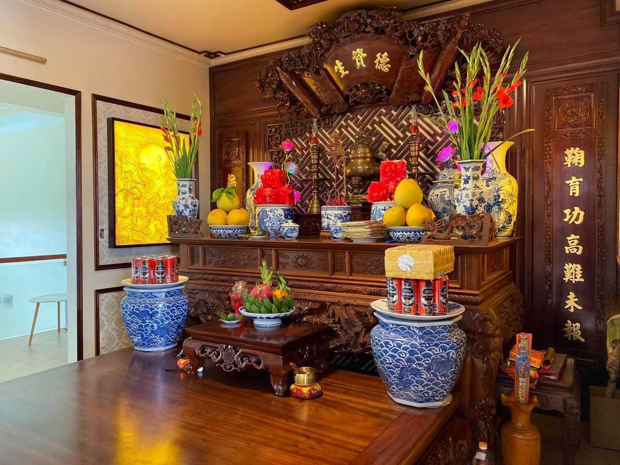 A traditional Vietnamese ancestral altar — featuring photographs of the deceased, an incense burner, fruit, and oil lamps