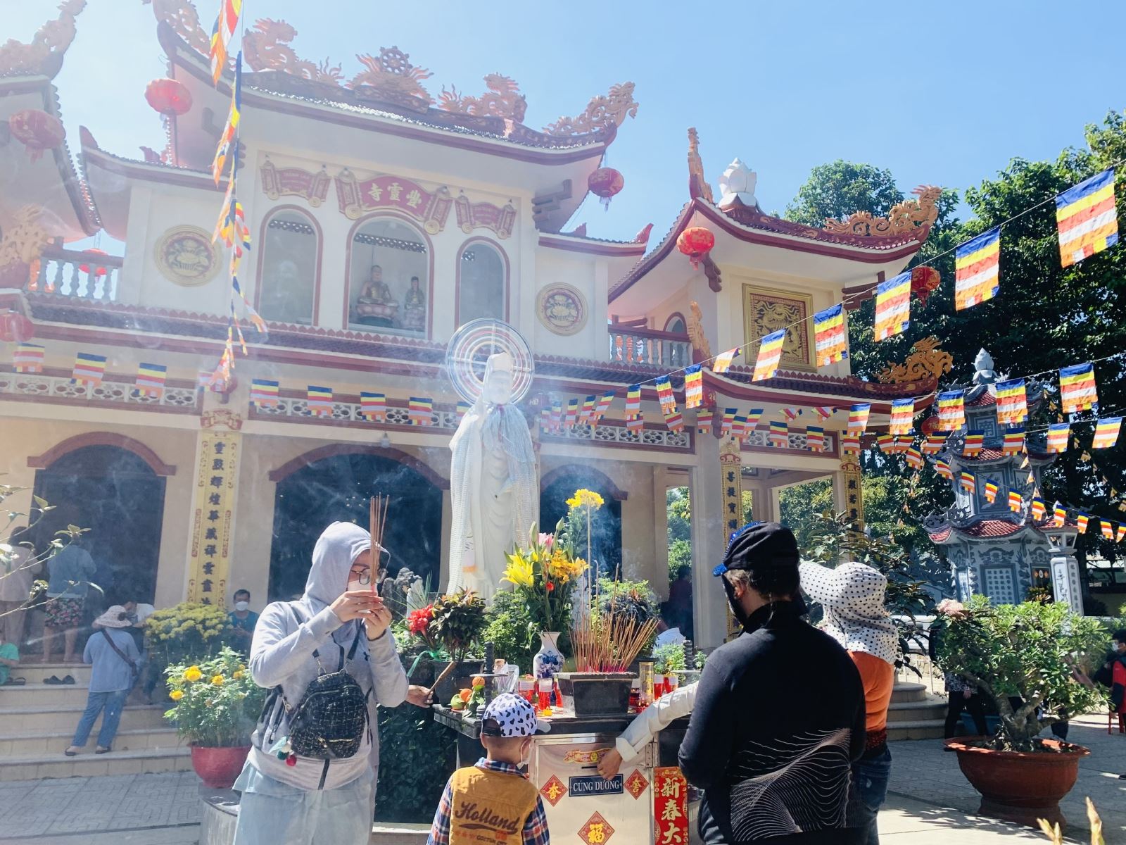 Citizens visiting the pagoda on the full moon — incense smoke, dressed in formal attire