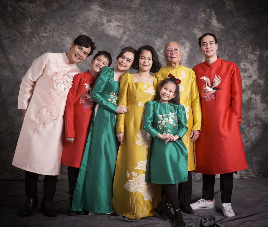 A three-generation Vietnamese family — grandparents in the center, surrounded by children and grandchildren