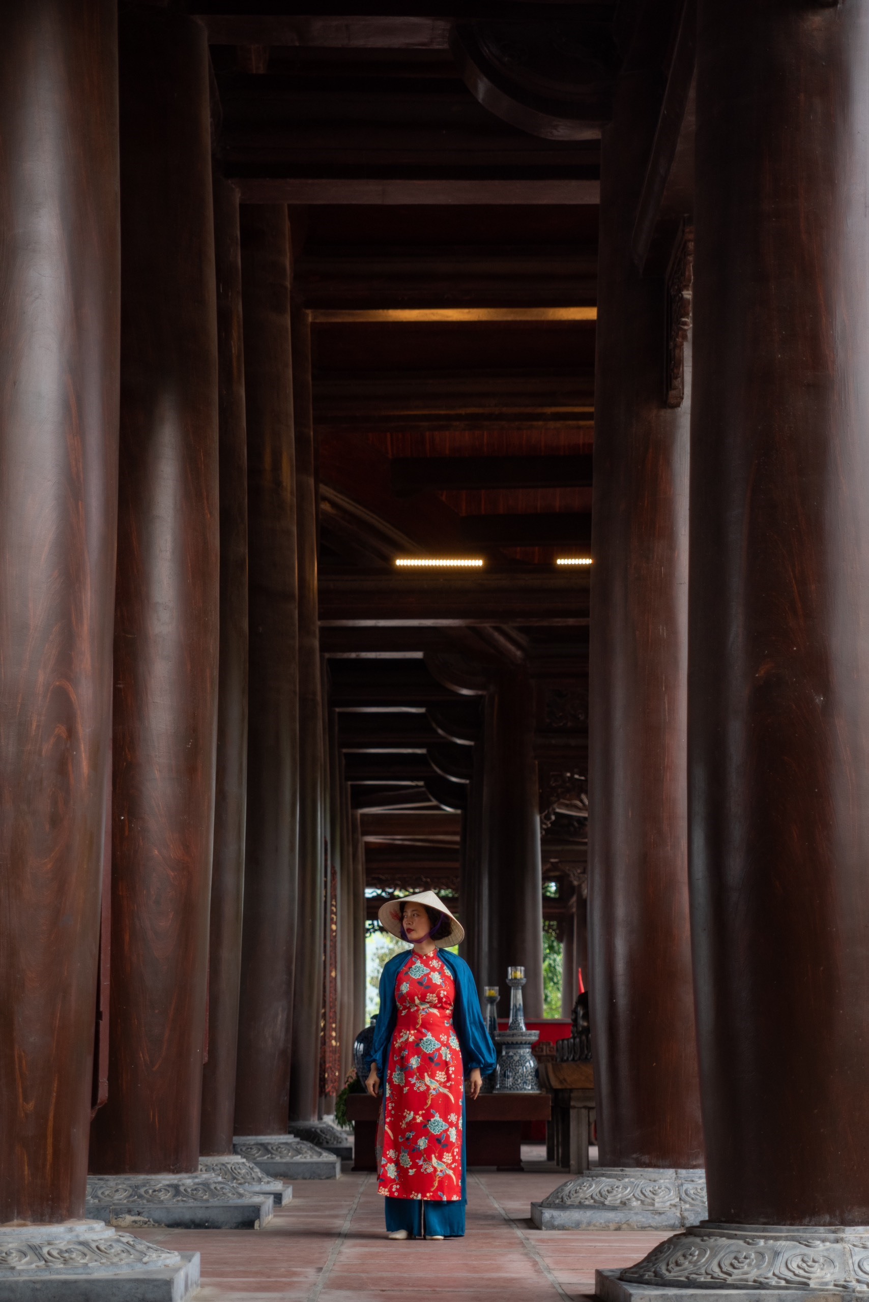 A person stepping through the temple door — bowing slightly, leading with the right foot