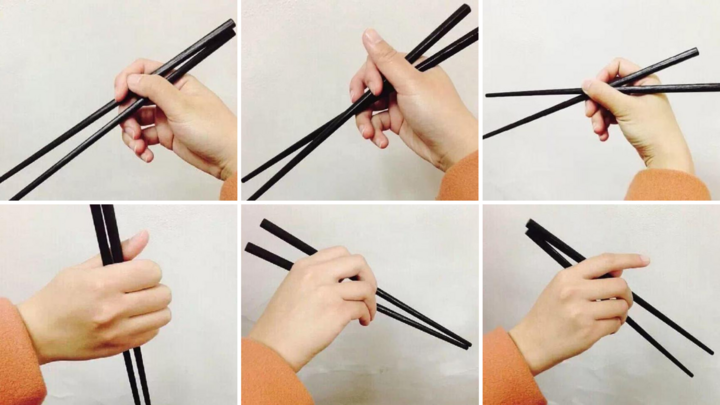 Holding chopsticks correctly — an Asian hand holding chopsticks elegantly