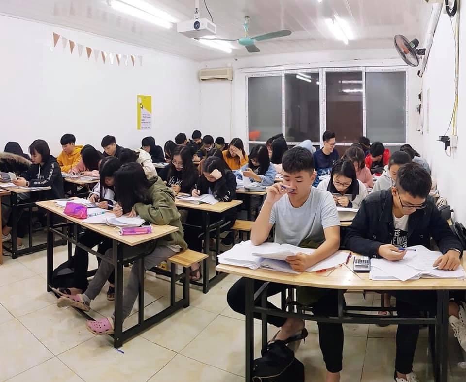 A late-night Vietnamese tutoring class — young students studying under harsh fluorescent lights