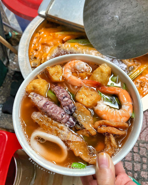A bowl of Thai noodles with all five flavors — sweet and sour broth, spicy chili, salty fish sauce, fragrant herbs