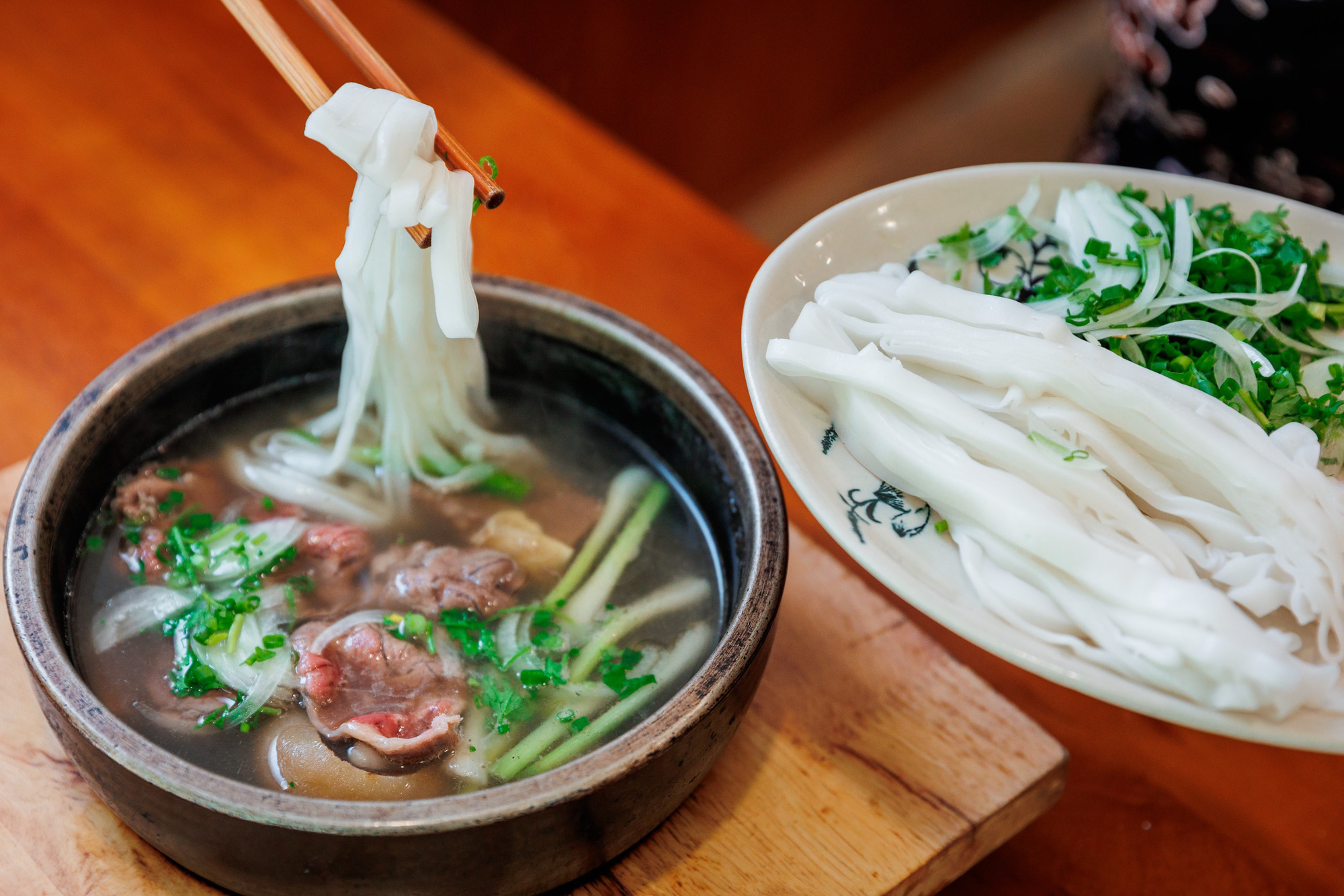 A Vietnamese Pho restaurant overseas — English and Vietnamese signs, a multi-ethnic clientele