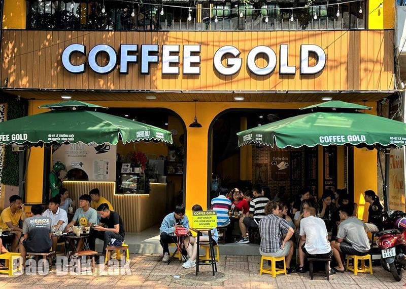 A Vietnamese sidewalk cafe — tiny plastic stools, patrons sitting and staring out at the street, glasses of coffee on the table