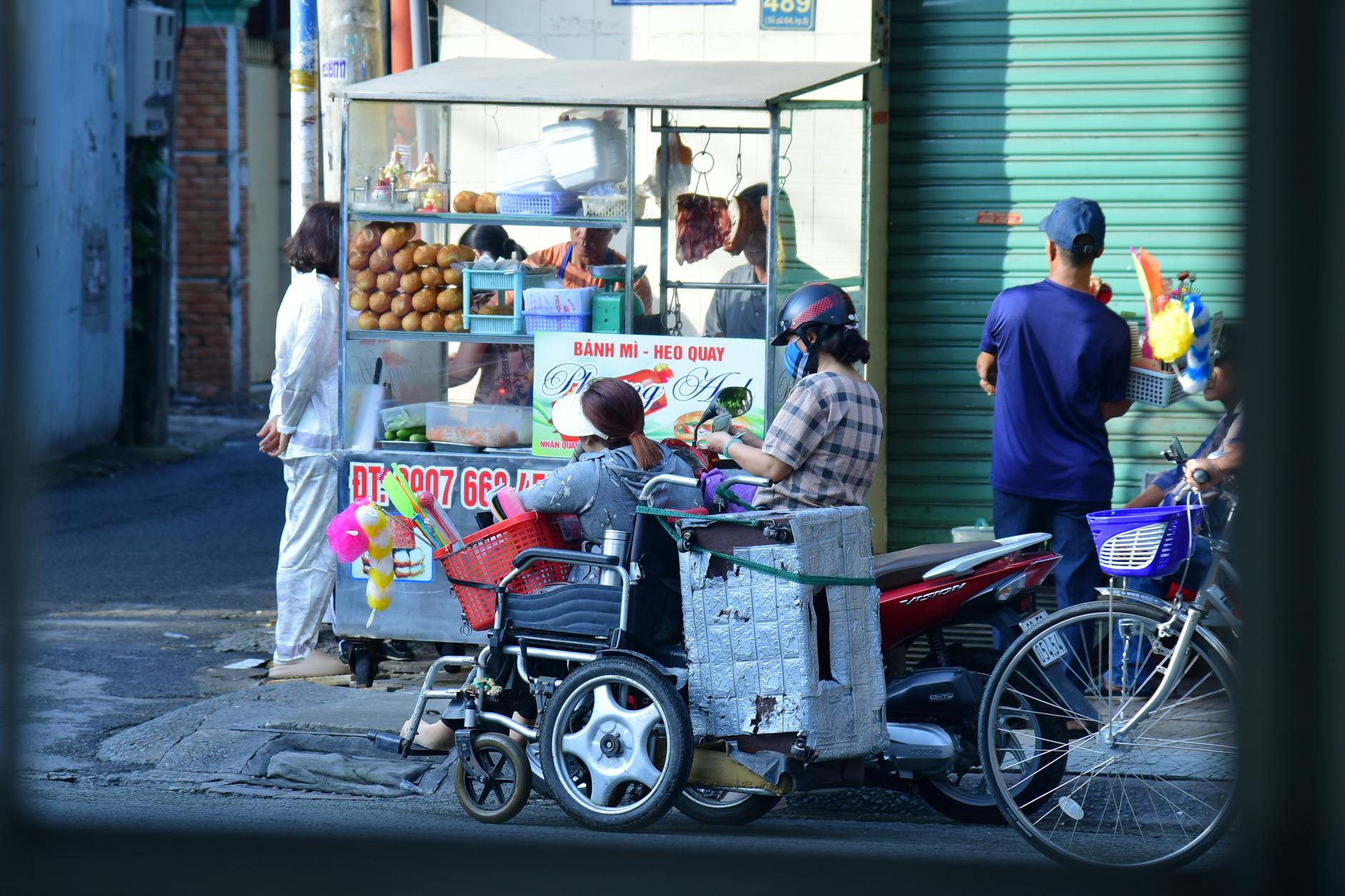 A bustling Banh Mi cart on the sidewalk in the morning — customers lining up — the vendor moving with blinding speed