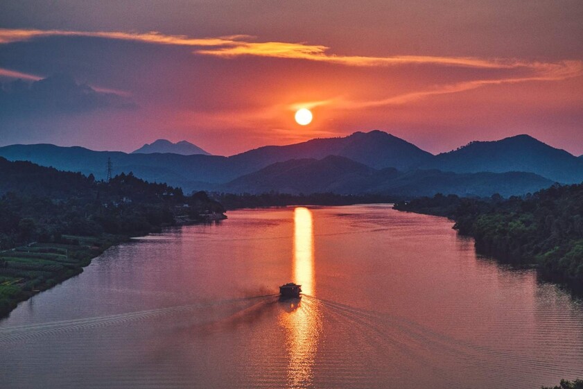 The Imperial Citadel of Hue reflecting onto the Perfume River — bathed in golden sunset light