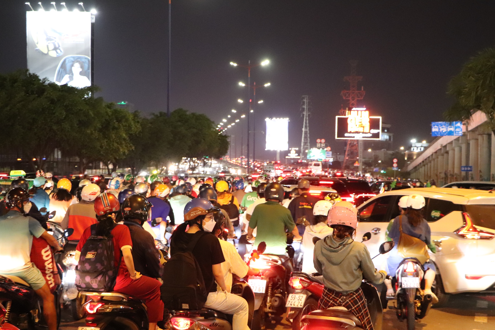 A massive flow of motorbikes during Saigon rush hour — a sea of vehicles in every direction, minimal space, yet flowing smoothly