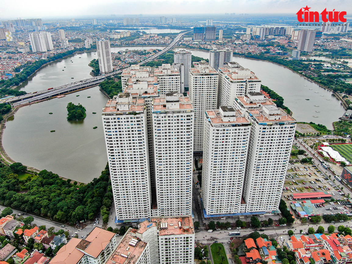 A newly constructed, massive high-rise apartment complex on the outskirts of Hanoi or Saigon — perfectly uniform, perfectly planned