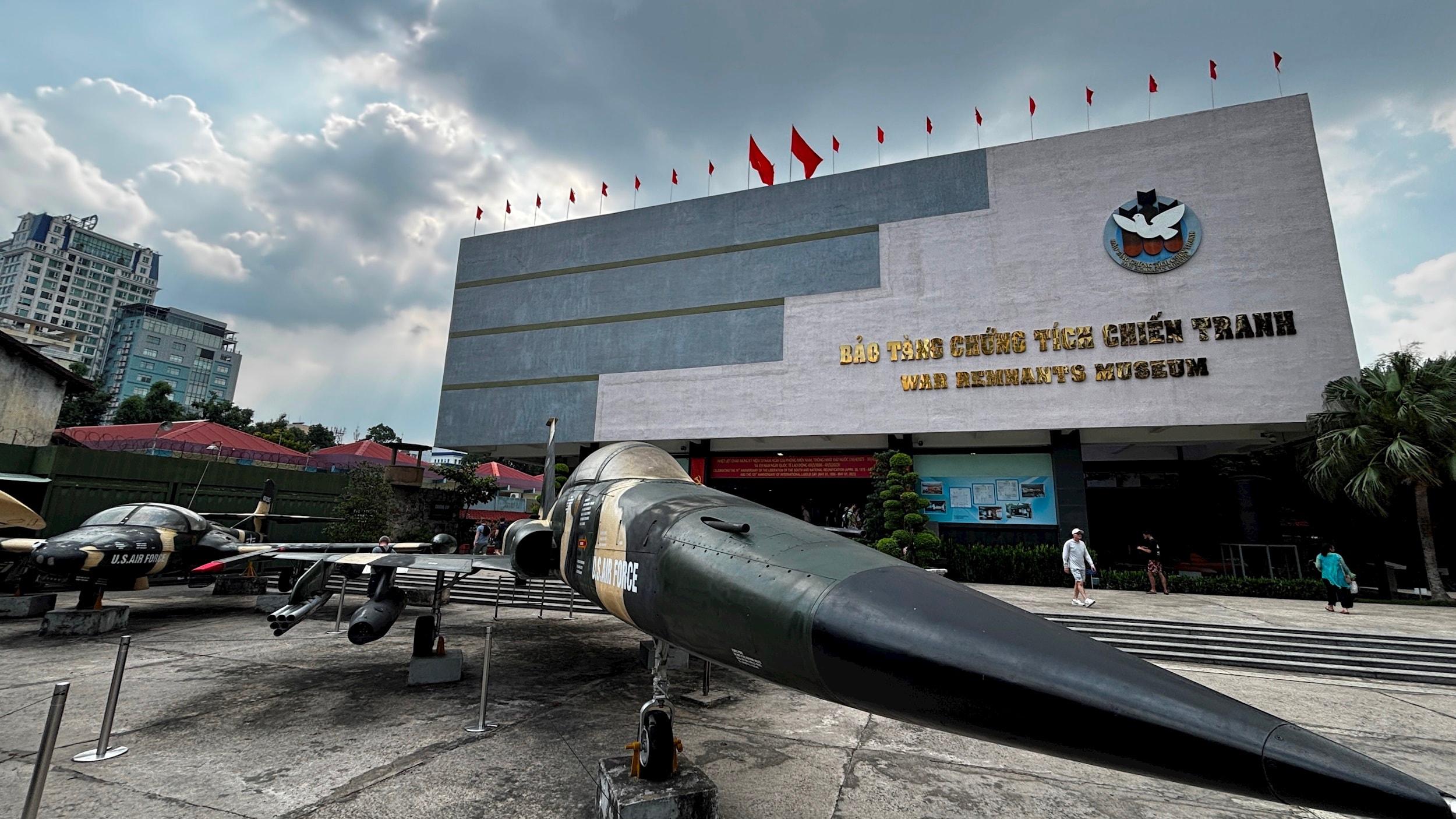 The War Remnants Museum in Saigon — Western tourists and Vietnamese locals observing historical imagery together