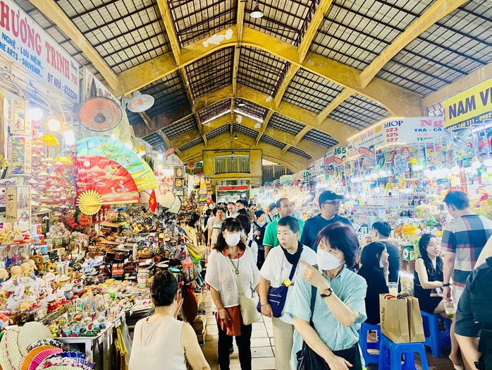 A tourist and a Vietnamese market vendor haggling — both are smiling
