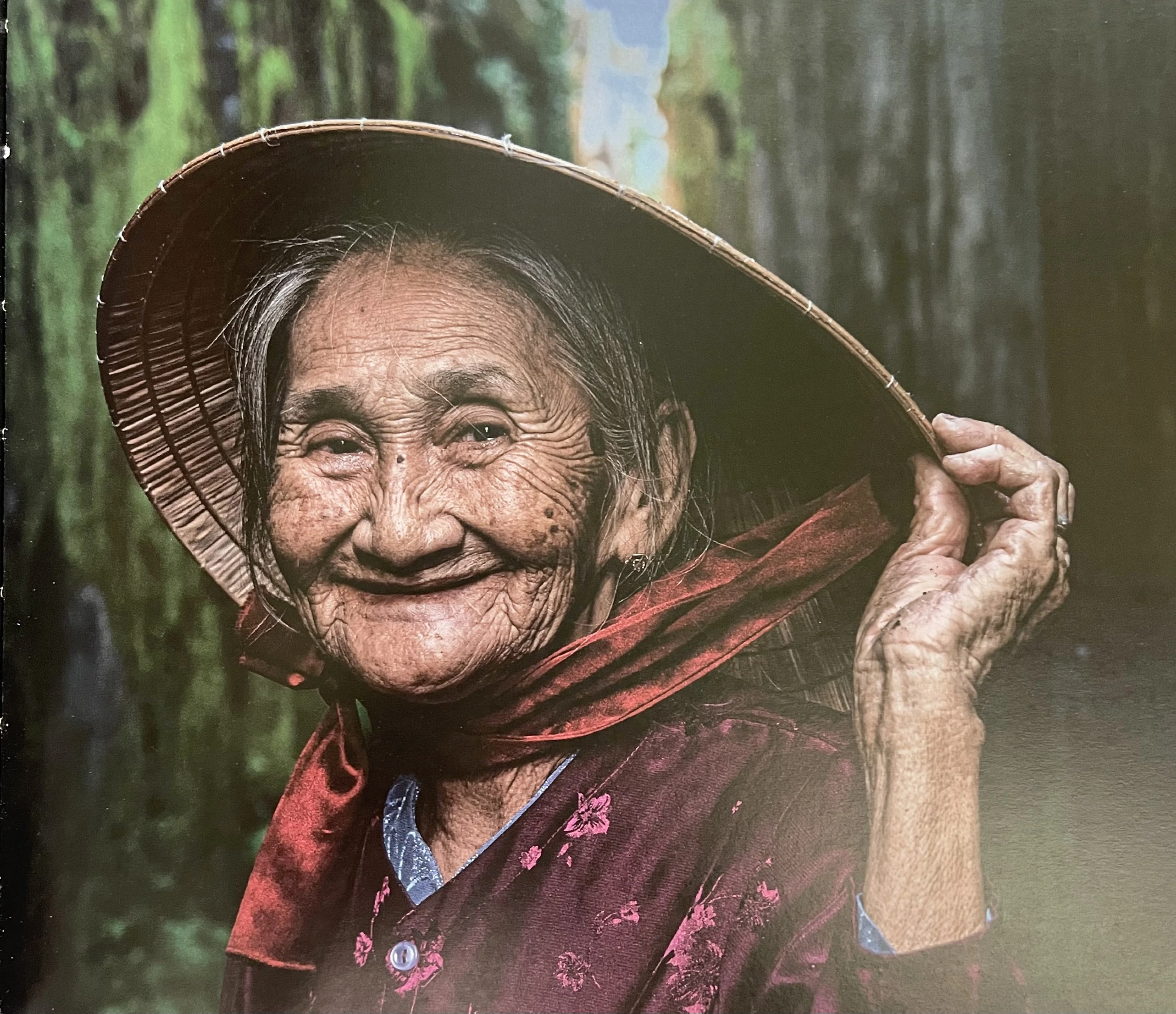 A Vietnamese individual sitting alone with a contemplative expression — urban background