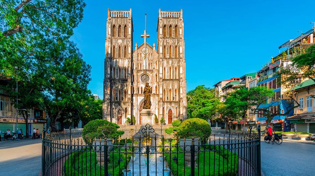 A massive cathedral in Hanoi or Saigon — French-European architecture, packed with Vietnamese parishioners