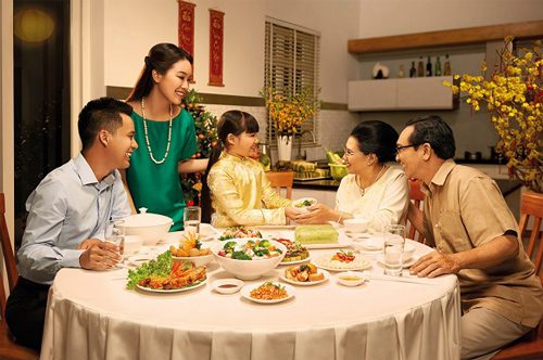 Family dinner in Vietnam abundant food host serving guest
